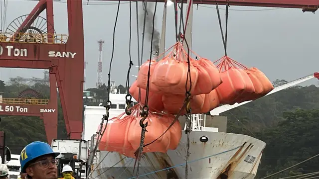 Orange big bags lifted by the ship's crane