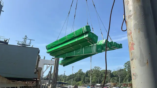 Green-wrapped steel bundles lifted from the vessel
