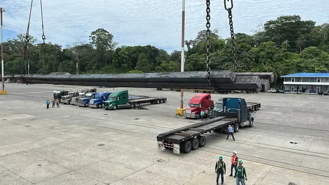 Long steel bundles lifted toward a waiting truck