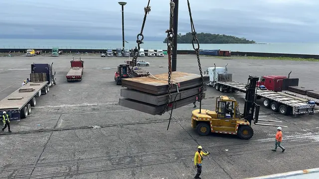 Steel plates landed in the port yard, with the sea and Isla Uvita behind