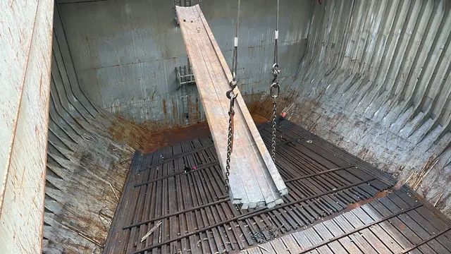 Steel beam lowered into an empty cargo hold