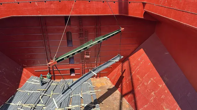 Steel section lowered into a red cargo hold