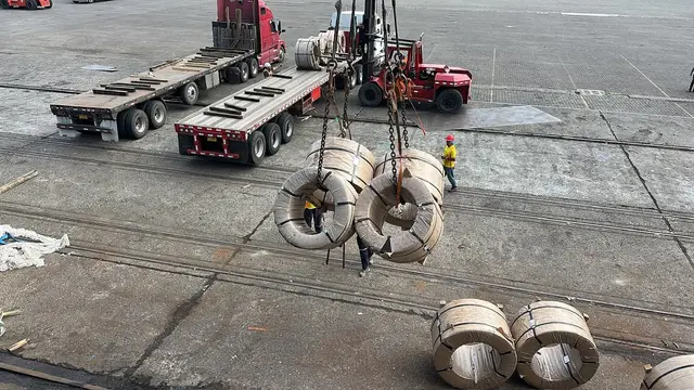 Wire coils lifted toward the trucks on the pier