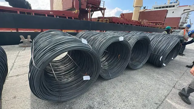Wire rod coils lined up on the pier next to the vessel